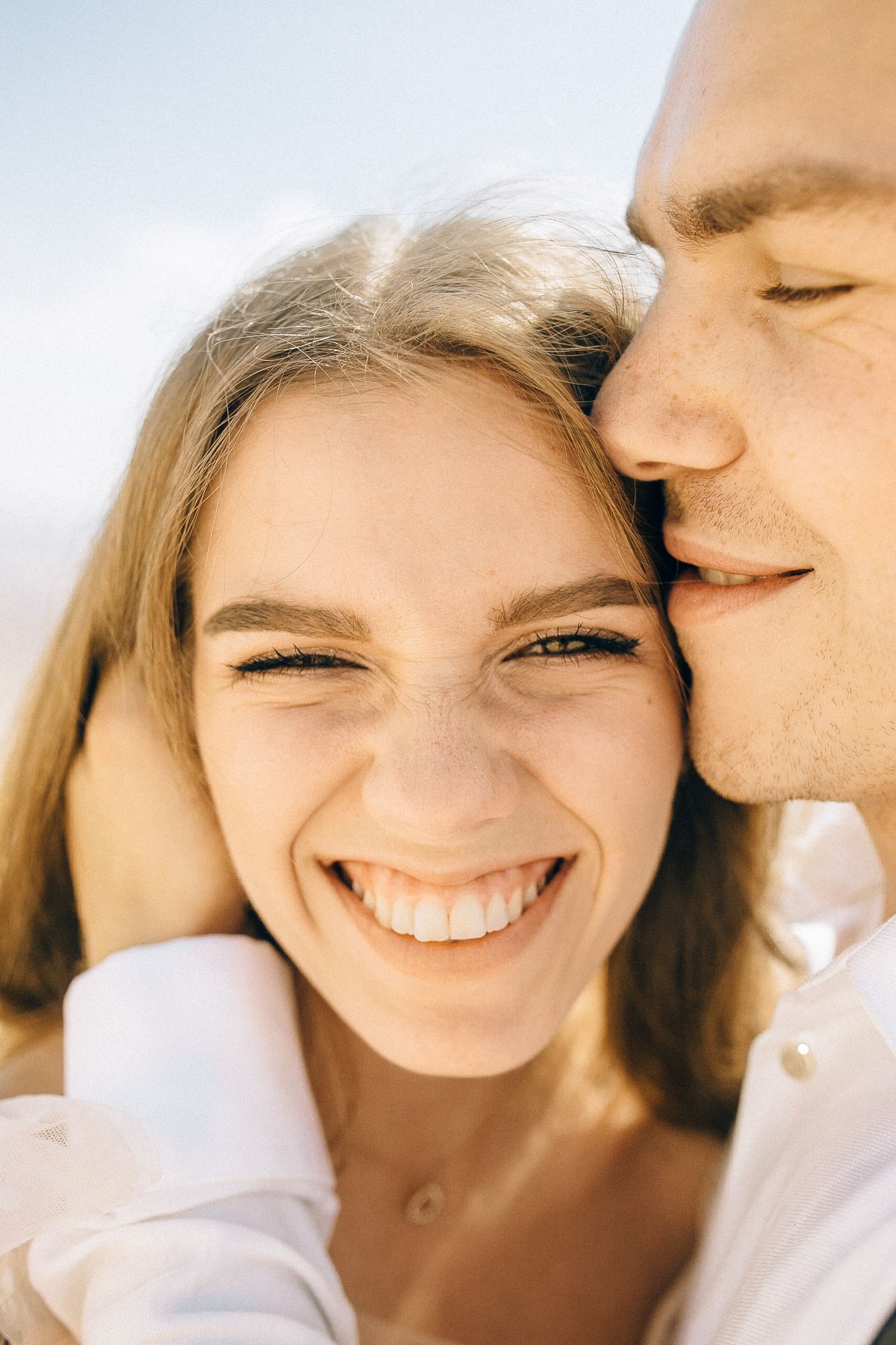 A couple smiling closely together outdoors