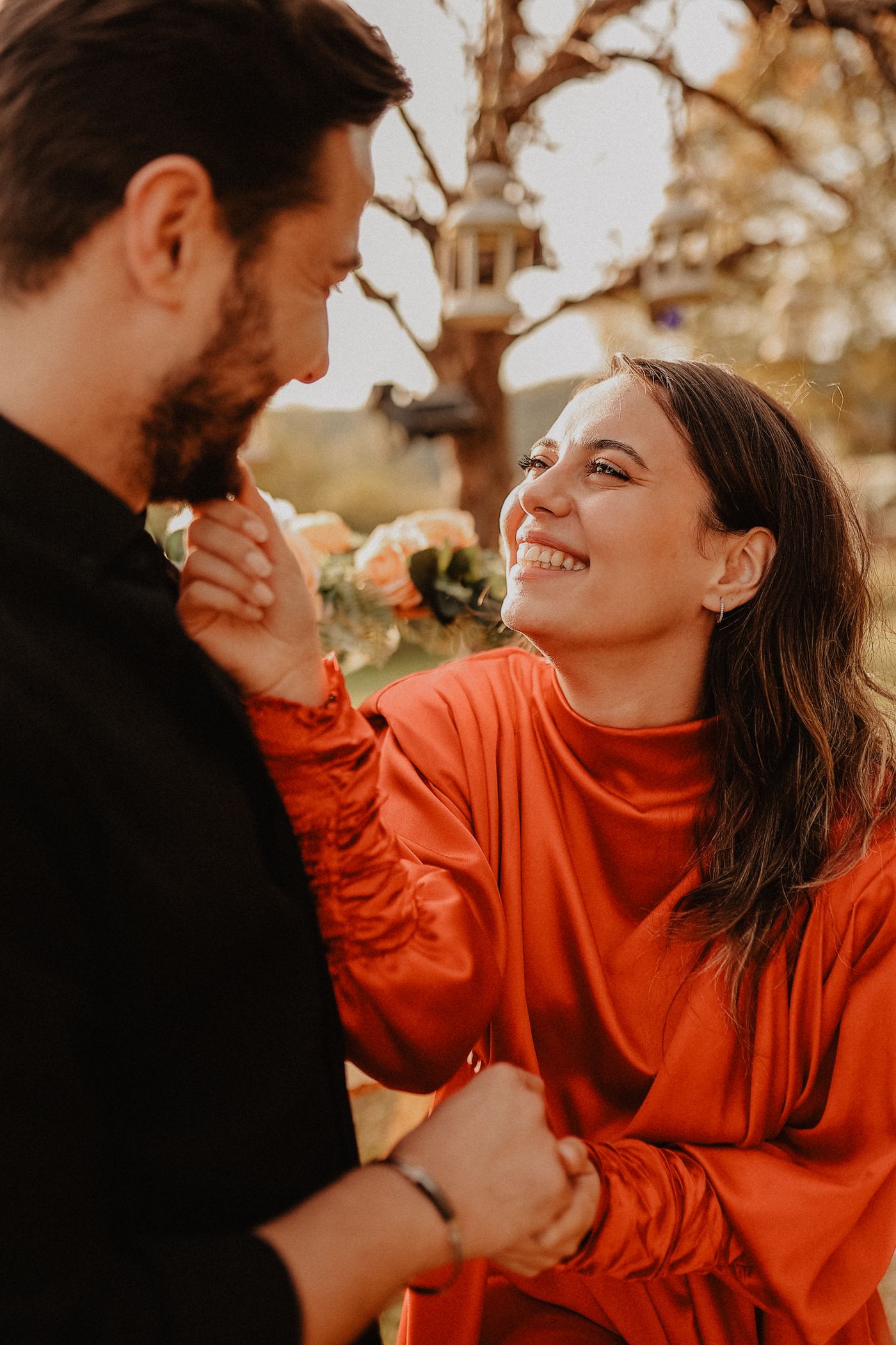 A couple laughing together outdoors in warm light